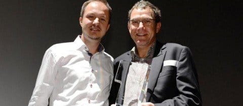 Zwei Männer stehen nebeneinander und halten eine Auszeichnung als stolze Empfänger der Microsoft Partner-Auszeichnung für das Jahr 2012 in der Hand.