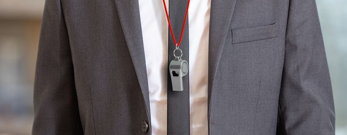 Ein Mann in Anzug und Krawatte mit rotem Schlüsselband, der seine ausgeprägten Kommunikationsfähigkeiten und sein Engagement für den Ehrenkodex bei der Zusammenarbeit unter Beweis stellt.