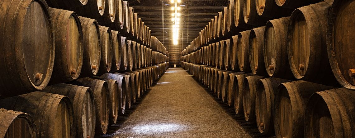 Eine Reihe von Holzfässern in einem Weinkeller, ein Beweis für die zeitlose Tradition der Weinherstellung.